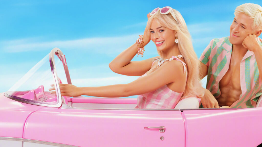 O filme live action da Barbie com Margot Robbie como Barbie dirigindo um carro rosa e Ryan Gosling como Ken na parte de trás do carro olhando para Barbie.